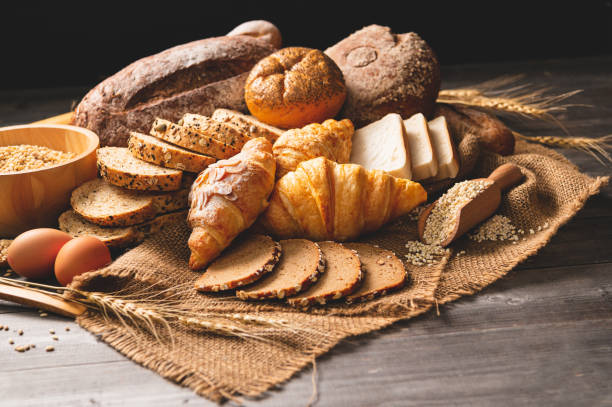 différents types de pain avec la nutrition des grains entiers sur le fond en bois. nourriture et boulangerie dans le concept de cuisine. délicieux petit déjeuner gouemet et repas. - mixed bread photos et images de collection