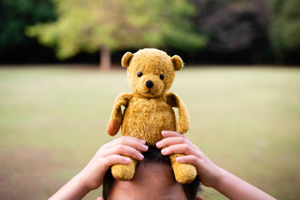 Teddy bear sitting on the child's head