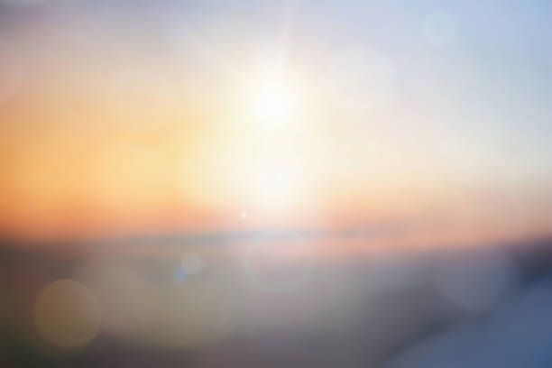 Natural background blurring warm colors and bright sun light. Bokeh or Christmas background Green Energy at sky sunny color orange light patterns plain abstract flare evening clouds blur.