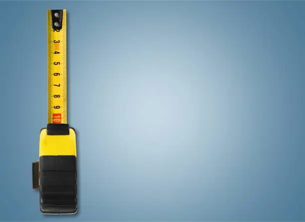 Yellow measuring tape isolated on blue background