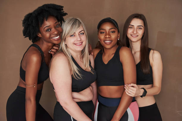 istock Friendship between different people. Group of multi ethnic women standing in the studio against brown background 1179788677