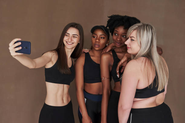 istock Making selfie. Group of multi ethnic women standing in the studio against brown background 1179788921
