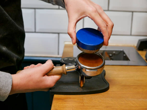 istock A barista using a push tamper to press down a portafilter basket filled with freshly ground coffee 1179790871