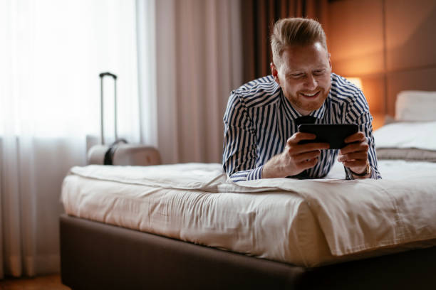 istock Businessman using phone in hotel room 1179792387