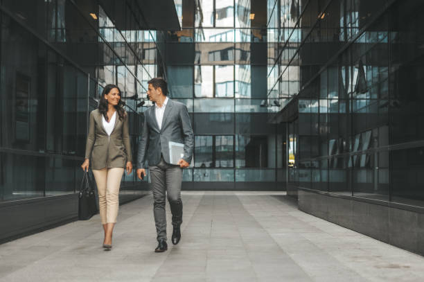 pareja de negocios frente al edificio de oficinas - street directory fotografías e imágenes de stock