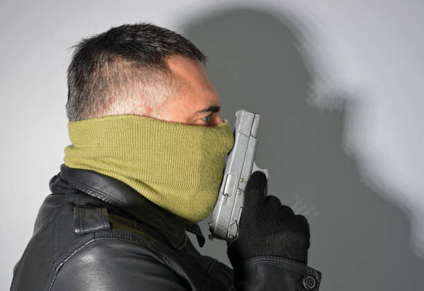 man in mask holding a pistol