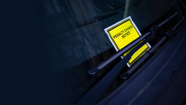 istock Bright yellow parking ticket tucked under the windscreen/windshield wiper with plenty of copy space 1179800846