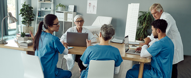 Cropped shot of a group of confident mature doctors having a discussion together inside of a doctor's office