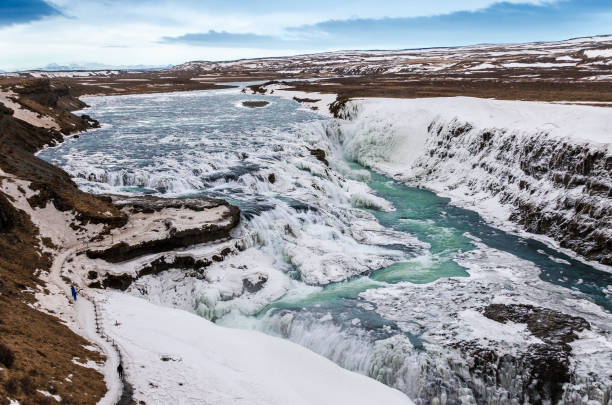 Glacial river of Iceland from blue water amid lava fields Hraunfossar, a waterfall formed by rivulets streaming over Hallmundarhraun, a lava field from volcano lying under the glacier Langjokull, and pour into the Hvita river, Iceland hraunfossar stock pictures, royalty-free photos & images