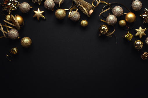 Christmas Flat Lay Background. Black Baubles on Dark Black Background. Minimalistic design. Copy Space. Horizontal.