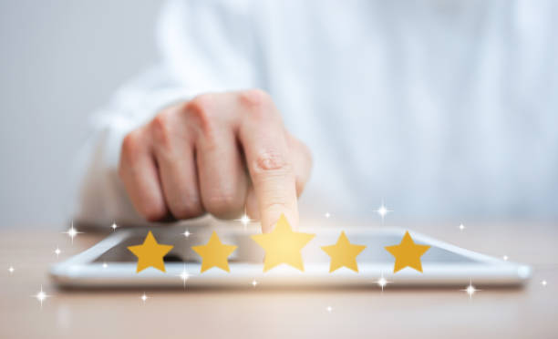 close up on customer man hand pressing on digital tablet screen with gold five star rating feedback icon and press level three rank (good) for giving score point to review the service , technology business concept - rating ranking quality control aspirations imagens e fotografias de stock