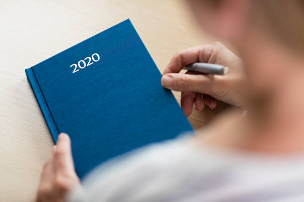 close up of woman opening new year 2020 diary on table - house pen people caucasian imagens e fotografias de stock