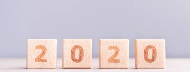 istock Abstract 2020, 2019 New year target plan design concept - wood blocks cubes on wooden table and pastel blue background, close up, blank copy space. 1179811056