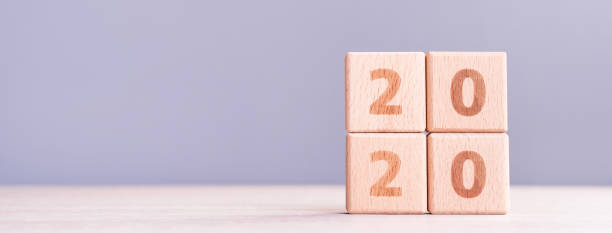 istock Abstract 2020, 2019 New year target plan design concept - wood blocks cubes on wooden table and pastel blue background, close up, blank copy space. 1179811077