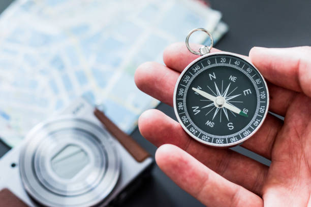 istock Young man on an adventure is holding a compass in his hand for finding is route 1179811210