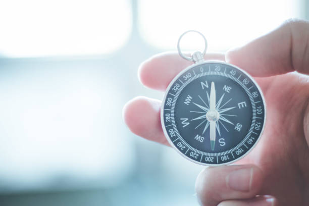 istock Innovation concept: Man is holding a compass in his hand, closeup cutout 1179811278