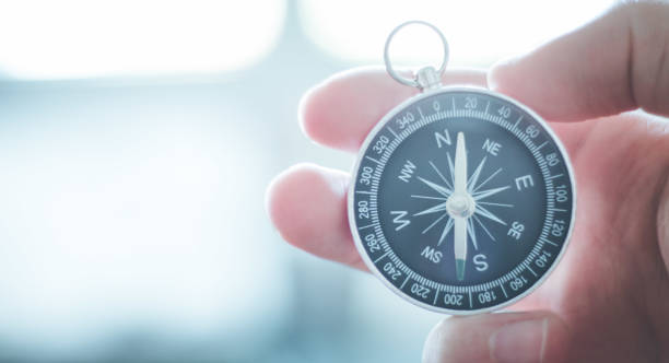 istock Innovation concept: Man is holding a compass in his hand, closeup cutout 1179811453