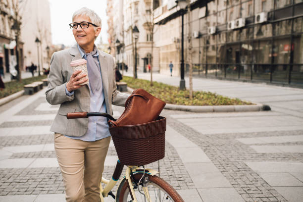 istock Woman with bicycle holding coffee 1179811967