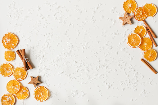 Composition of cinnamon and dried oranges on white background. Flat lay, top view. Copy space for your design. Christmas or New Year concept