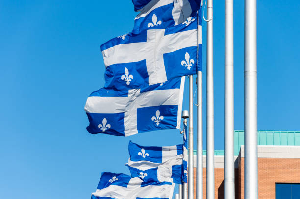 Quebec Flags in Quebec City Quebec Flags waving in the wind against blue sky in Quebec City. st jean saint barthelemy stock pictures, royalty-free photos & images