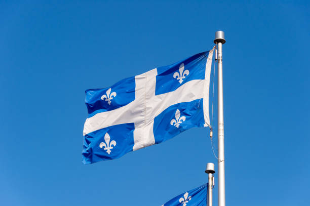 Quebec Flag in Quebec City Quebec Flag waving in the wind against blue sky in Quebec City. st jean saint barthelemy stock pictures, royalty-free photos & images