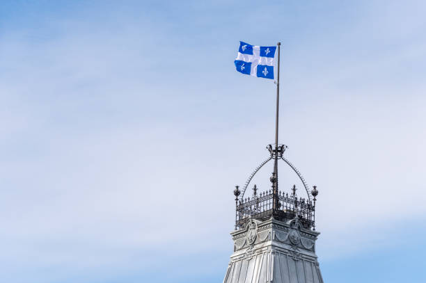 Quebec Flag in Quebec City Quebec Flag at the top of the Quebec Parliament building in Quebec City. st jean saint barthelemy stock pictures, royalty-free photos & images