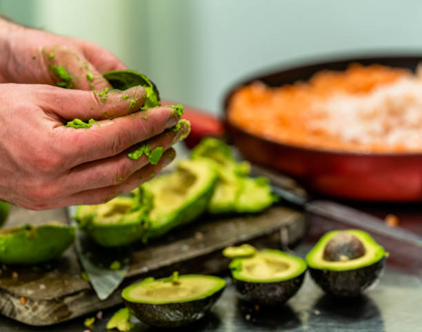 istock Male Chef Pealing Avocado for  Wedding Meal 1179816154