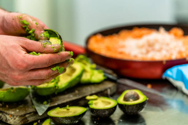 istock Male Chef Pealing Avocado for  Wedding Meal 1179816224