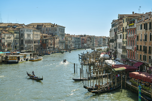 Venice, Italy - April 19, 2019: Busy traffic on Canal Grande close to Rialto Bridge in Venice, Italy during sunny day in April 2019