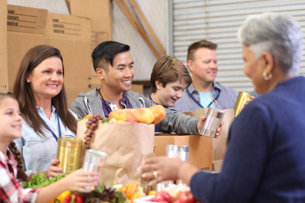 istock Multi-ethnic group of volunteers serves food at soup kitchen. 1179822409