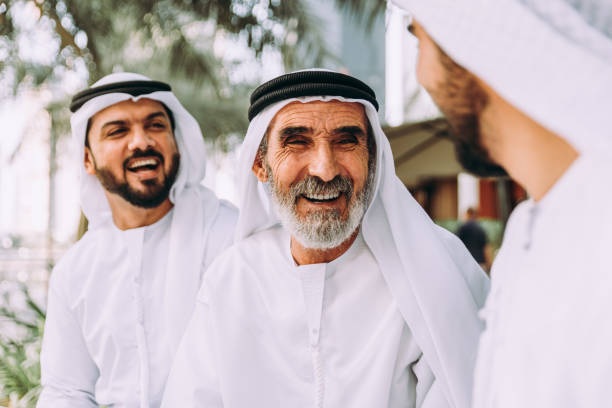 tres hombres de negocios caminando en dubái con ropa tradicional de emiratí - retirement grandfather senior adult child fotografías e imágenes de stock