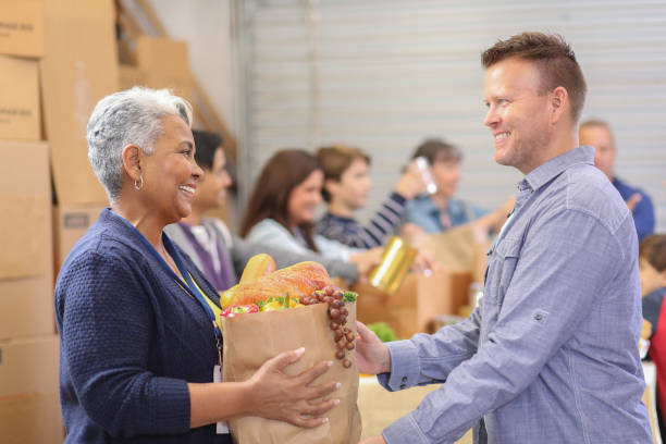 istock Multi-ethnic group of volunteers work at food bank. 1179825049