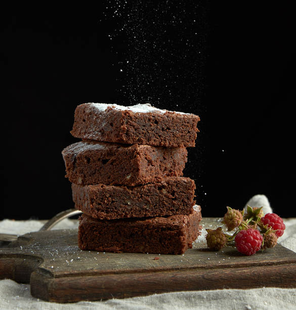 istock stack of square baked brownie chocolate cake slices sprinkled with white sugar 1179828281