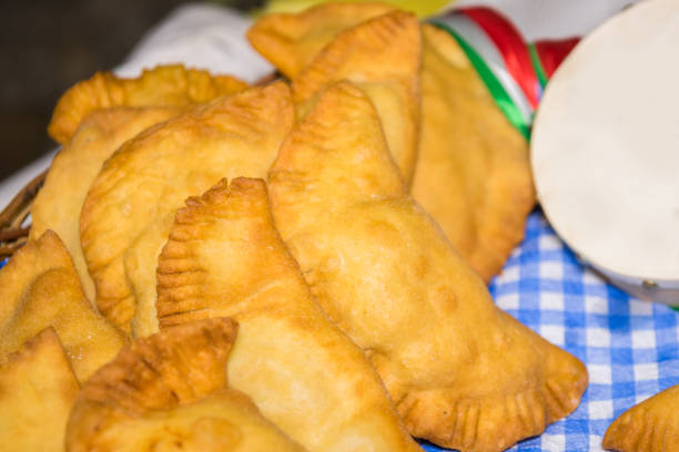 istock Puglia food: fried pies called panzerotti in a basket, made with tomato sauce, mozzarella and prosciutto, close-up with tambourine of Salento 1179829892