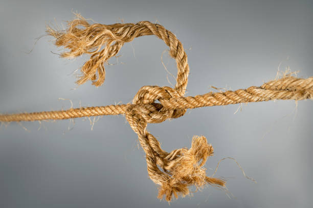istock Rough ropes connected by large knot on gray background 1179836070