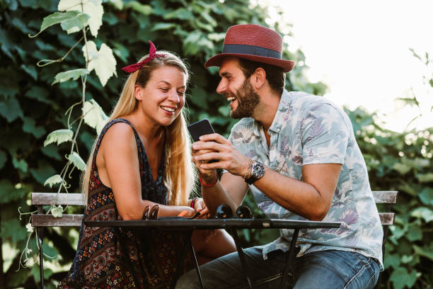 istock Young couple sitting on the terrace using smartphone 1179837875