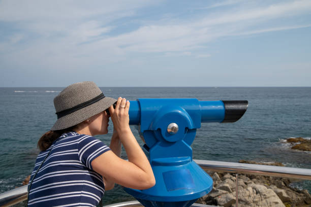 istock Young woman watching in blue telescope 1179839627