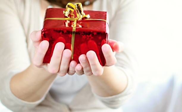 istock woman holding Christmas present 1179843454