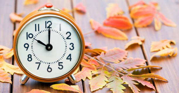 istock Retro alarm clock with autumn leaves, daylight savings time concept, web banner 1179845025