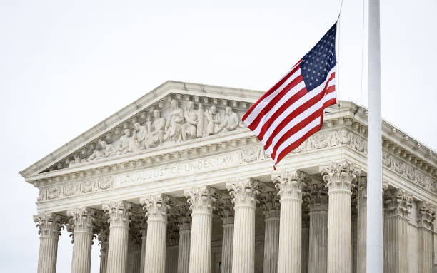 Supreme Court A picture of the supreme court, with the US flag waving in front of the phrase "Equal Justice Under Law" supreme court justice photos stock pictures, royalty-free photos & images