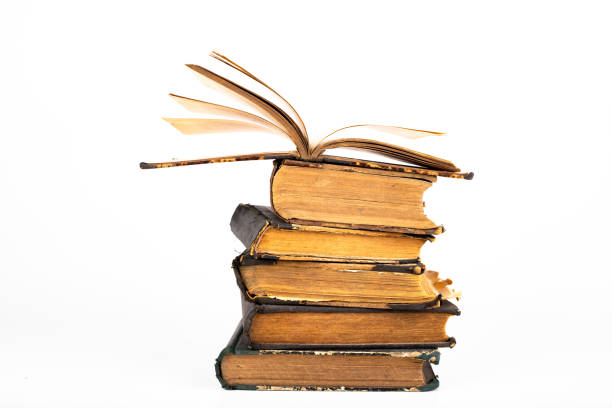 istock Old dusty books on a light countertop. Library items in old bindings. White background. 1179847664