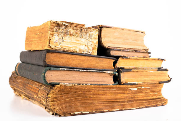 istock Old dusty books on a light countertop. Library items in old bindings. White background. 1179847711