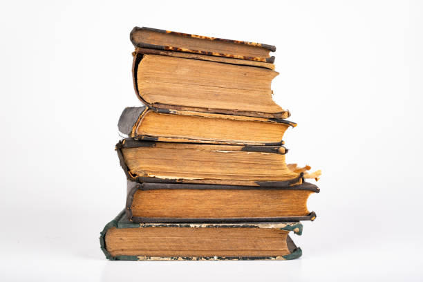 istock Old dusty books on a light countertop. Library items in old bindings. White background. 1179847807