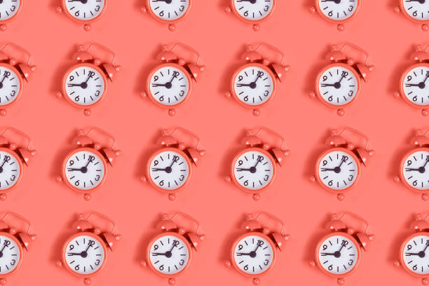 istock Pattern of alarm clock on coral. 1179850360