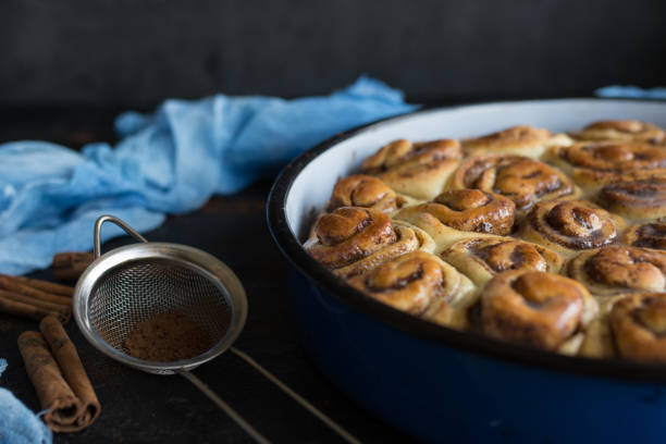 istock Cinnamon roll tart with sugar syrup in vintage baking pan on black background 1179852363
