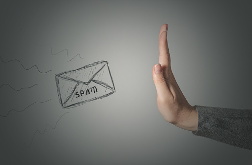 Stop spam concept. Stop gesture by female hand and spam letter on gray background.