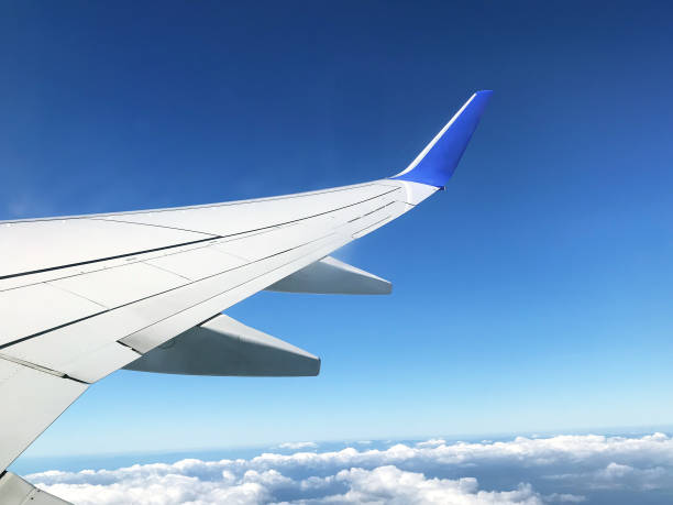 istock View from airplane illuiminator at the wing, cloudy sky. 1179854903