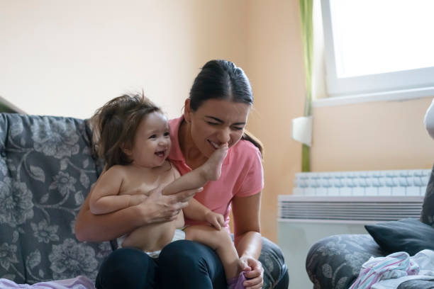 istock Mother dressing her little daughter at home 1179855331