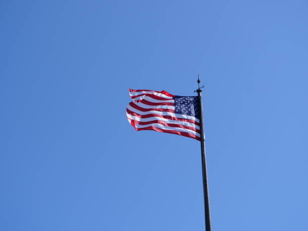 istock American Flag Waving Against Clear Blue Sky 1179855459