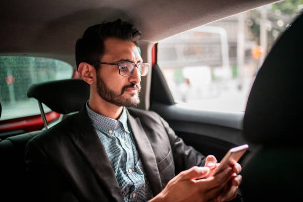 istock Businessman traveling by car and using a smartphone 1179856534